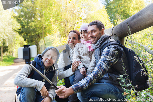 Image of family with backpacks taking selfie and hiking