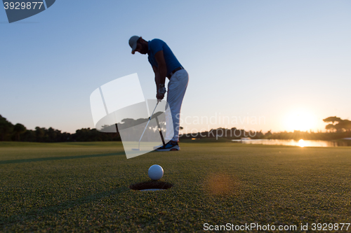 Image of golfer  hitting shot at golf course