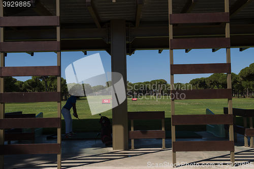 Image of golf player practicing shot on training