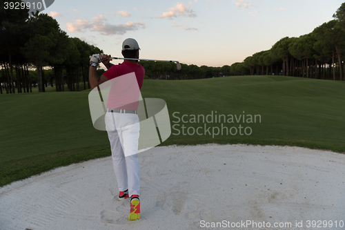 Image of golfer hitting a sand bunker shot on sunset