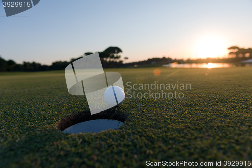 Image of golf ball on edge of  the hole