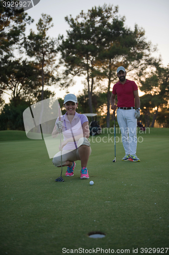 Image of couple on golf course at sunset