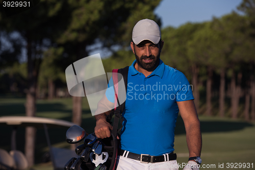 Image of golfer  walking and carrying golf  bag