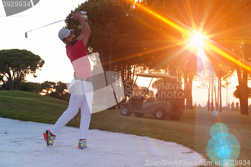 Image of golfer hitting a sand bunker shot on sunset