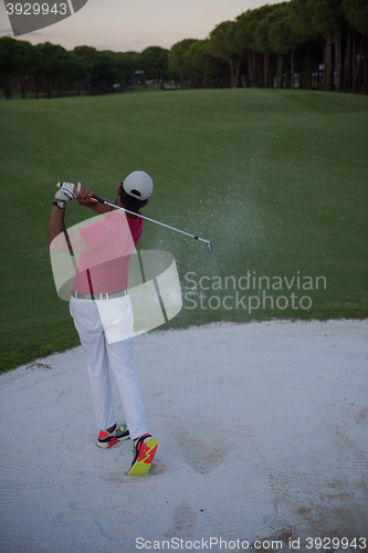 Image of golfer hitting a sand bunker shot on sunset