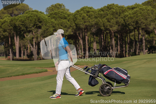 Image of golf player walking with wheel bag