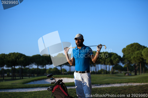 Image of golfer  portrait at golf course on sunset