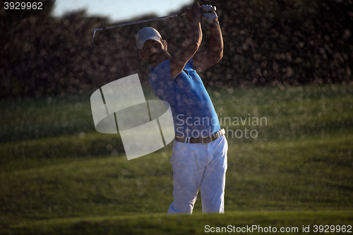 Image of golfer hitting a sand bunker shot on sunset