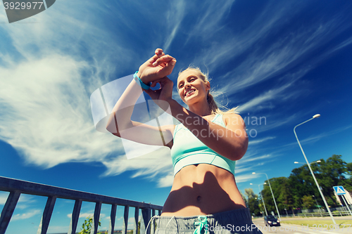 Image of happy woman with heart rate watch and earphones