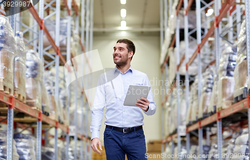 Image of happy businessman with tablet pc at warehouse