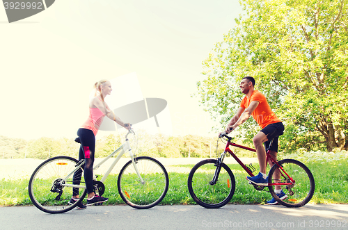 Image of happy couple riding bicycle outdoors