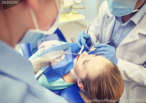 Image of close up of dentist treating female patient teeth