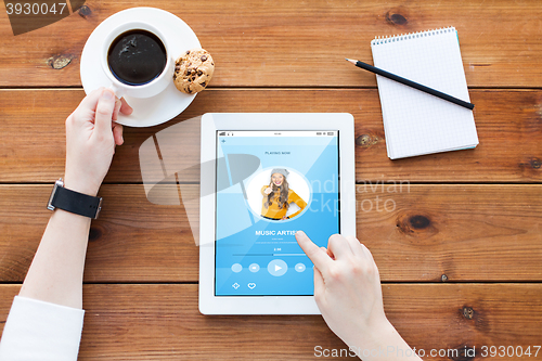 Image of close up of woman with tablet pc on wooden table