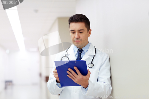 Image of doctor with clipboard at hospital corridor