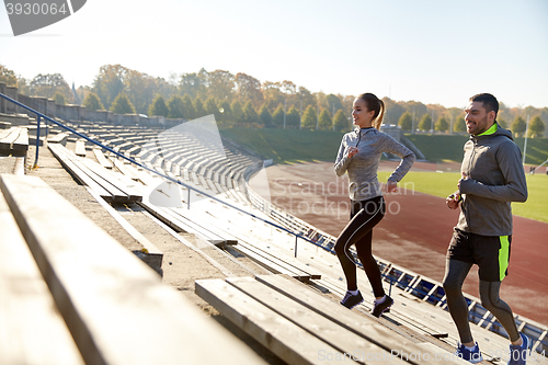 Image of happy couple running upstairs on stadium