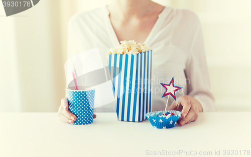 Image of woman eating popcorn with drink and candies