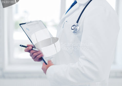 Image of male doctor with stethoscope writing prescription