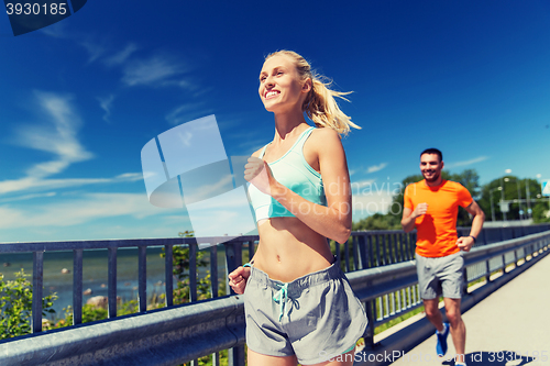 Image of smiling couple running at summer seaside