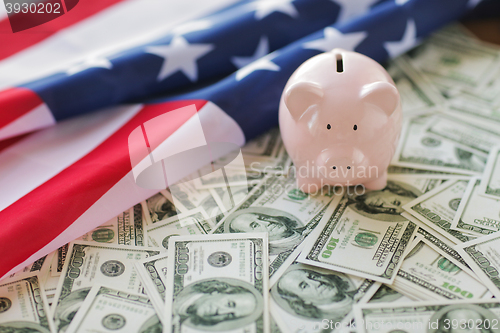 Image of close up of american flag, piggy bank and money