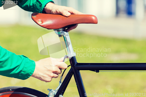 Image of close up of man adjusting fixed gear bike saddle