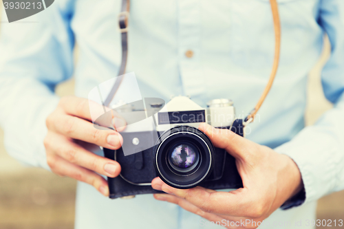 Image of close up of hipster man with film camera in city