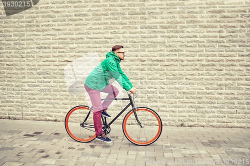 Image of young hipster man riding fixed gear bike