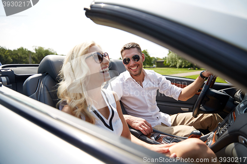 Image of happy man and woman driving in cabriolet car