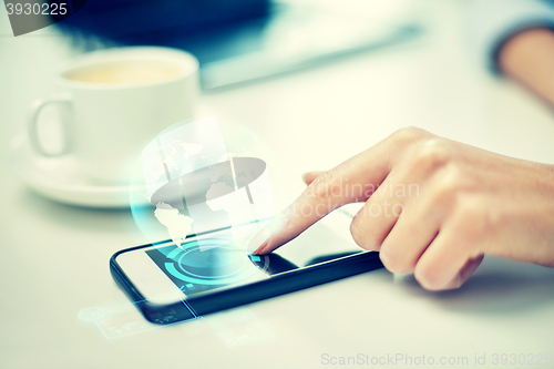 Image of close up of woman hand with smartphone and globe
