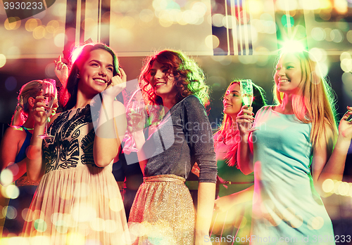 Image of smiling friends with glasses of champagne in club