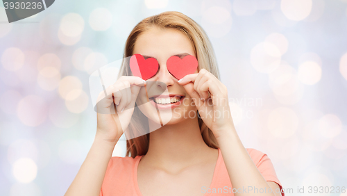 Image of happy young woman with red heart shapes on eyes