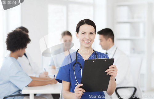 Image of happy doctor over group of medics at hospital