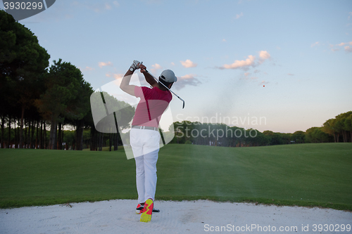 Image of golfer hitting a sand bunker shot on sunset