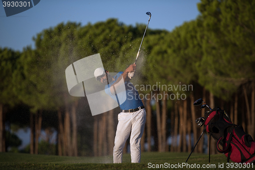 Image of golfer hitting a sand bunker shot on sunset