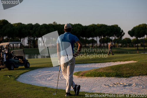 Image of golfer from back at course looking to hole in distance