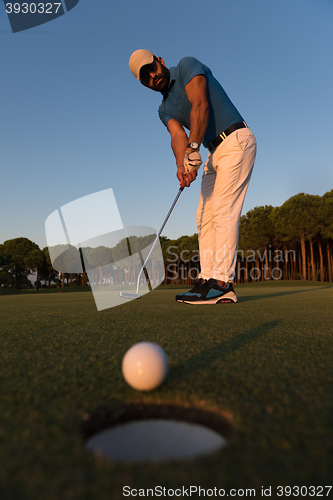 Image of golfer  hitting shot at golf course