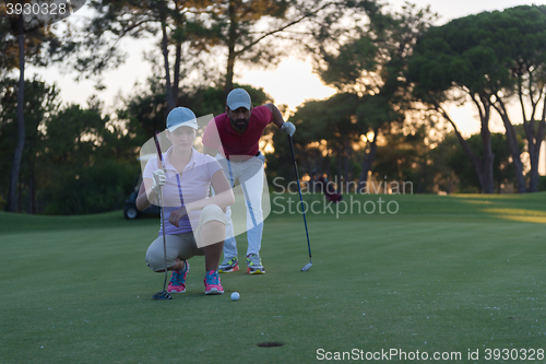 Image of couple on golf course at sunset