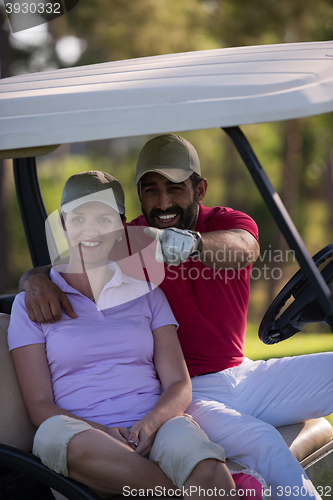 Image of couple in buggy on golf course