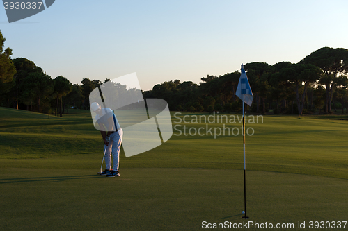 Image of golfer hitting ball to hole