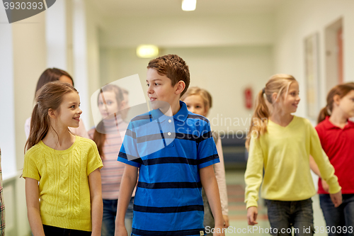 Image of group of smiling school kids walking in corridor