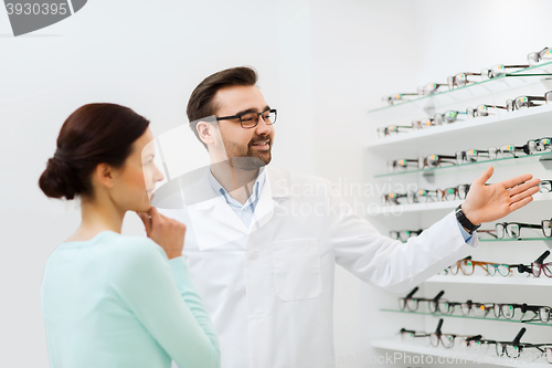 Image of woman and optician showing glasses at optics store