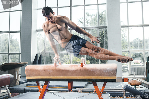 Image of The sportsman during difficult exercise, sports gymnastics