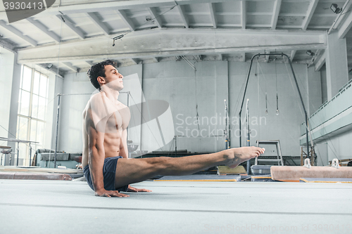 Image of caucasian man gymnastic acrobatics equilibrium posture at gym background