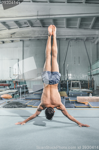 Image of caucasian man gymnastic acrobatics equilibrium posture at gym background