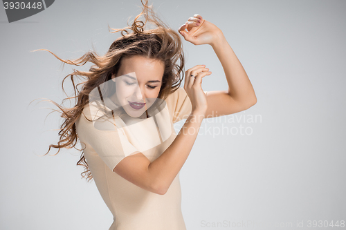 Image of The woman with hair blowing in the wind on gray