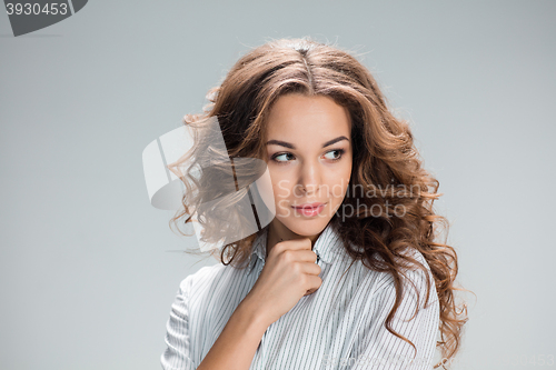 Image of The happy thoughtful woman on gray background