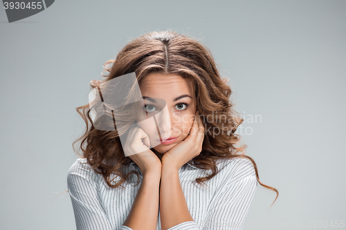 Image of The happy thoughtful woman on gray background
