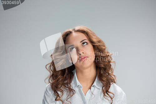 Image of The happy thoughtful woman on gray background