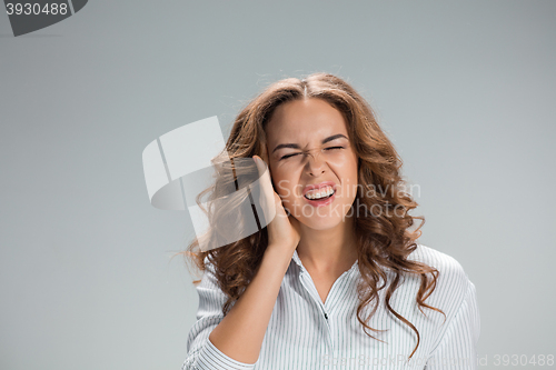 Image of The young woman with earache over gray