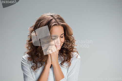 Image of Woman is looking imploring over gray background