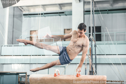 Image of The sportsman during difficult exercise, sports gymnastics